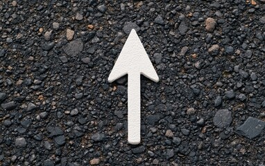 Asphalt road with white arrow roadway. White arrow on asphalt captured mid-motion from a drone's perspective, symbolizing progression and flow