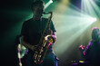 © Zamrznuti tonovi - Saxophonist performing live music on stage with band