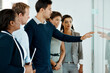© peopleimages.com - Teaching, glass wall and business people in meeting for teamwork, brainstorming or project. Creative, ideas or employees with cooperation, group and leadership with coaching, talking and training