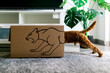 © ADDICTIVE STOCK - Curious dog enters box with playful lion design in cozy room