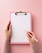 © SandraSevJarocka - female hands holding pink pen and pink clipboard with paper