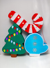 Wall Mural - Christmas piñatas with candies: Christmas tree, red Christmas candy and blue mitten with snowflakes