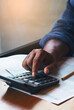 © prachid - Business man use calculator, smartphone, and review tax form at home office. Financial advisor hand plan and calculate budget. Business and Financial Planning Concept-vertical image.