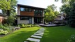 © Design By Reiga - Modern house backyard with stone pathway, deck, and lush green lawn.