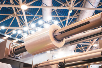Poster - Automatic polyethylene plastic bag production machine with lighting effect. Close-up of the roller of the plastic bag production machine in the light blue scene. product packaging concept