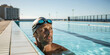 © blinkstud.io - Hipster man at a swimming pool with goggles, coach or giving lessons, handsome