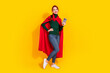 © deagreez - Full length photo of cheerful pretty lady dressed green jumper red mantle texting modern device empty space isolated yellow color background