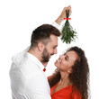 © New Africa - Lovely couple under mistletoe bunch on white background