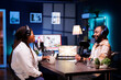 © DC Studio - Cheerful african american content creators producing podcasts and hosting live chats for online listeners. Black man and woman broadcasting their talk show via recording audio equipment.