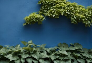 Wall Mural - green leaves cascading over a textured blue wall background in a natural style