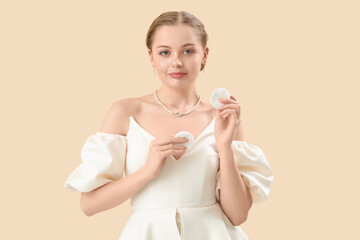 Wall Mural - Young woman with cotton pads on beige background