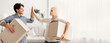 © Prostock-studio - Moving New Home. Cheerful Spouses Giving High-Five Carrying Packed Boxes In Own Flat, Copy Space