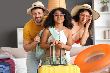 Wall Mural - Happy family with suitcase and inflatable rings at home. Travel concept