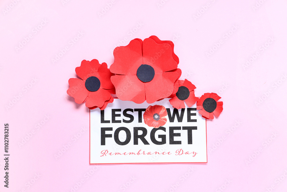 Paper poppy flowers and card on pink background. Remembrance Day