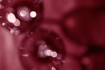Wall Mural - wine glasses defocused, red wine color blurred background with light flare, optical blur, bokeh. top