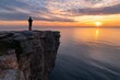 © Babb - A man stands on a cliff overlooking the ocean at sunset