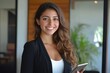 © Vooglo - Portrait of young Hispanic professional business woman standing in office