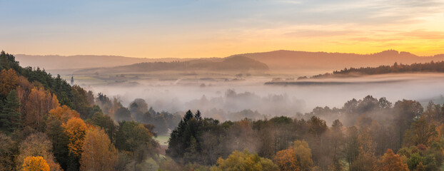 Wall Mural - panoramic view of forest with morning fog in autumn at sunrise