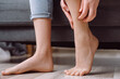 © Yura Yarema - Foot pain concept. Close up of young woman with scratch feet, itch foot, problem itchy skin on sofa at home, dermatitis from fungus, fungal bacterial infection, allergic reaction, eczema