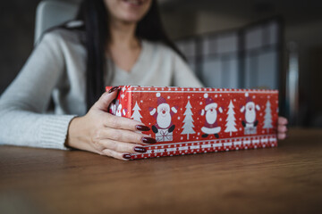 woman hold gift with Santa Claus paper for Christmas on wooden table