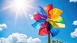 © Sampao - Colorful Windmill Toy Against Bright Sunny Sky with Fluffy Clouds