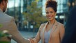 © Johannes - Business people, handshake and meeting in city for partnership, greeting or introduction and welcome outdoors. Happy woman with smile shaking hands for b2b, collaboration or agreement in deal outside
