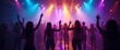 © kotlyarn - A lively crowd is dancing under vibrant, colorful stage lights at a concert or event. The scene captures the energy, music, and excitement of live performances.