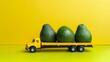 © utaem2022 - Yellow toy truck carrying fresh avocados on yellow background