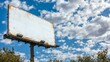 © Galib - A blank billboard with a rusty surface against a blue sky with white clouds.