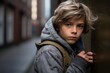 © Inigo - Portrait of a boy in a gray jacket on the street.