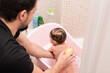 © Antonio Recena - father cleaning his son in home bathtub