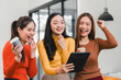 © kenchiro168 - Three women joyfully celebrating while viewing tablet together in modern office. Their expressions reflect excitement and camaraderie, creating lively atmosphere