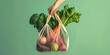 © RM Graphics - Hand holding bag with fresh vegetables over green background