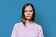 © Valerii Honcharuk - Headshot portrait of young serious woman on blue background