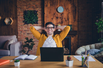 Young man enjoying a relaxing day at home while working on his laptop in a stylish living room with cozy interior design