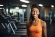 © NikoG - Smiling portrait of a young African American female fitness trainer in gym