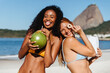 © (JLco) Julia Amaral - Playful young women at Praia do Flamengo beach with coconut drinks and snacks