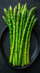 Wall Mural - Freshly harvested asparagus arranged beautifully on a black plate evoking a healthy dining experience