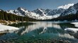 © claudunia - Alpine lake surrounded by snow-capped mountains and clear water.
