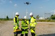© narong - Wind turbine or windmill worker woman or technician control drone to work with her co-worker team in workplace field during day time.