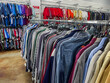 © Scott Habermann - Thrift store clothing rack with selection of preowned secondhand shirts on hangers.