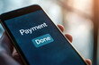 © Alina - Hand holding smartphone with text Payment Done on mobile screen