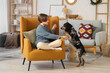 © Pixel-Shot - Little boy with cute cocker spaniel sitting in armchair at home