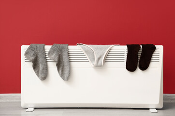 Panties and socks on heating radiator near color wall