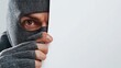© Орися Зигмунд - A male person wearing a black balaclava peeks around a blank wall, exuding an atmosphere of stealth and secrecy.