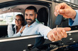 © Zamrznuti tonovi - Cheerful couple in car receive keys; marking new ownership