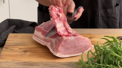 Canvas Print - cook housekeeper remove bones of pork chop with knife on wooden board in kitchen. process of making homemade meal, cooking at home, food closeup, cooking pork roast