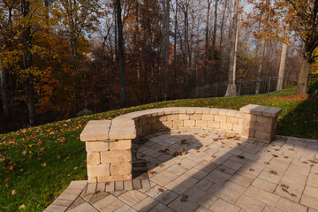 Wall Mural - A serene backyard featuring a curved stone patio surrounded by vibrant autumn foliage, creating a peaceful outdoor space ideal for relaxation and nature appreciation.