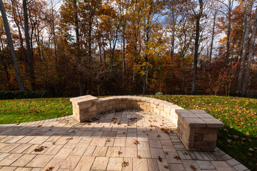 Wall Mural - A serene backyard featuring a curved stone patio surrounded by vibrant autumn foliage, creating a peaceful outdoor space ideal for relaxation and nature appreciation.