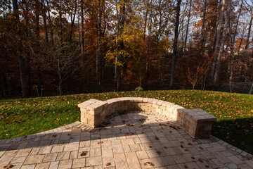 Wall Mural - A serene backyard featuring a curved stone patio surrounded by vibrant autumn foliage, creating a peaceful outdoor space ideal for relaxation and nature appreciation.